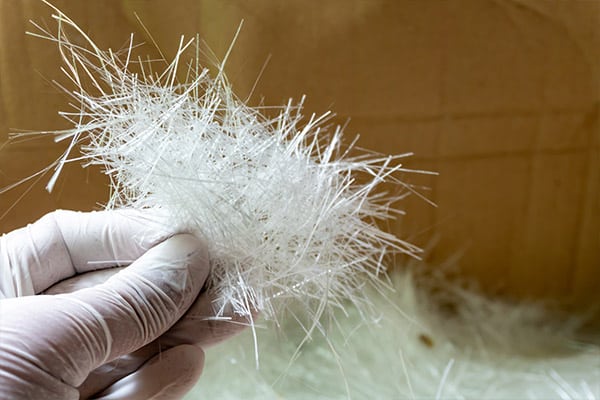 Hand holding a bunch of fibres in a factory